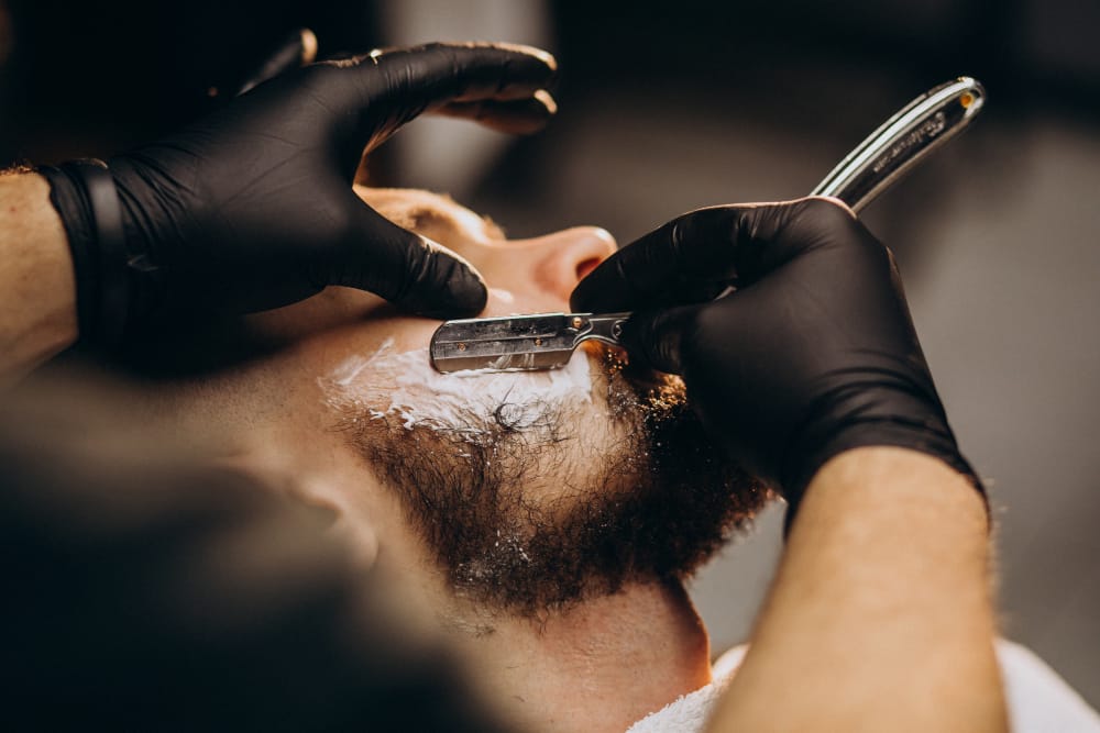 Barber giving a client a straight-razor beard shave